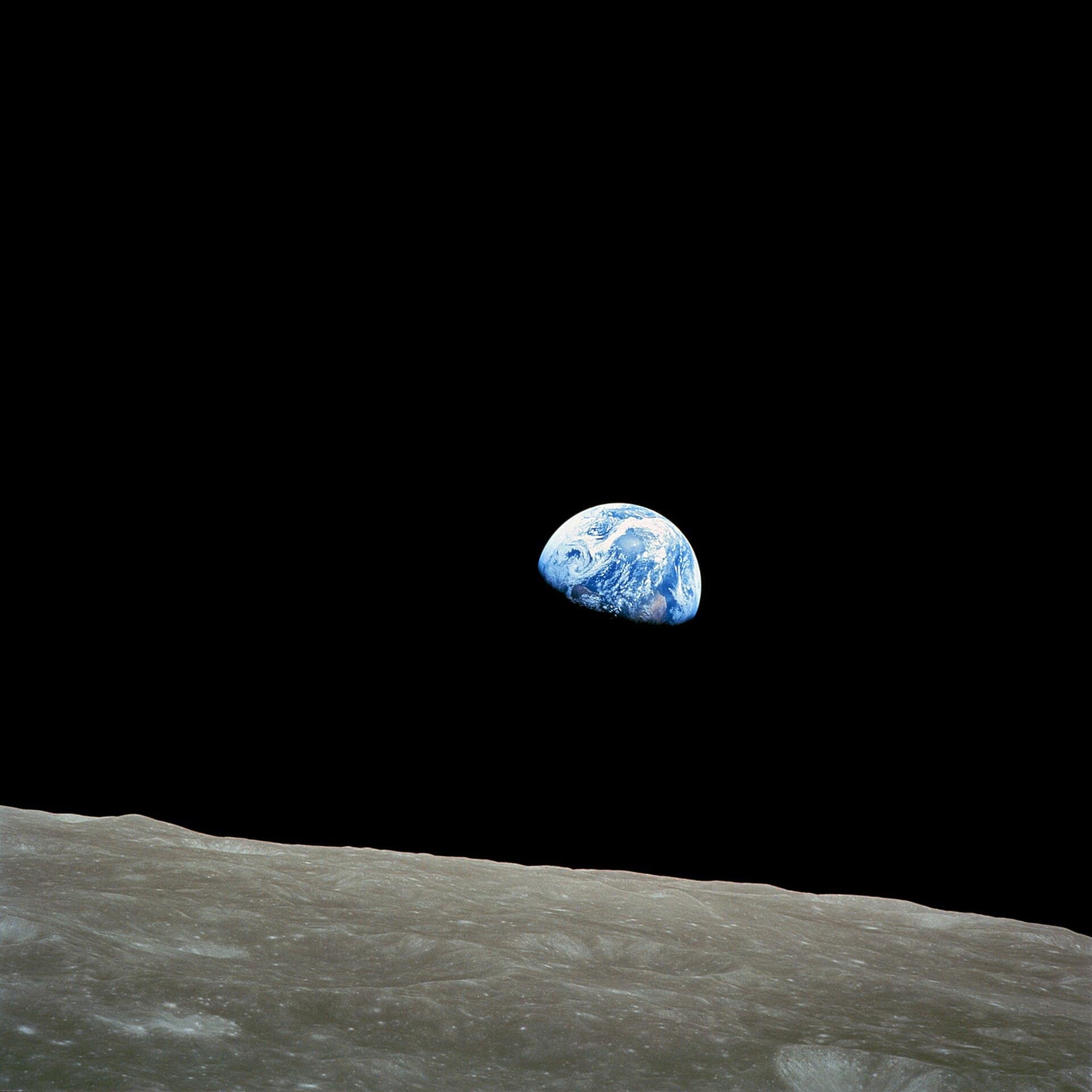 Earth rising over the grey surface of the Moon, photographed from Apollo 8